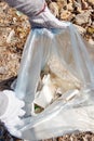 Young woman cleaning beach area and showing plastic in a bag Royalty Free Stock Photo