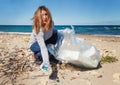 Young woman cleaning beach area and showing plastic bottle lids in hand Royalty Free Stock Photo