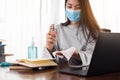 Young woman cleaning desk at workplace in the office