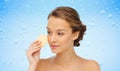 Young woman cleaning face with exfoliating sponge Royalty Free Stock Photo