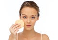 Young woman cleaning face with exfoliating sponge Royalty Free Stock Photo