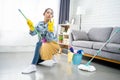 Young woman cleaning floor at home doing chores. She enjoys housework Royalty Free Stock Photo