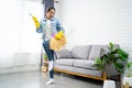 Young woman cleaning floor at home doing chores. She uses a broom instead of a guitar Royalty Free Stock Photo