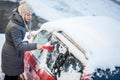 Young woman cleaning her car from snow and frost Royalty Free Stock Photo