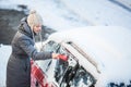 Young woman cleaning her car from snow and frost Royalty Free Stock Photo