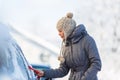 Young woman cleaning her car from snow and frost Royalty Free Stock Photo