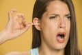 Young woman cleaning her ears with cotton sticks Royalty Free Stock Photo