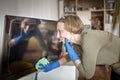 Woman cleans home wipes dust from tv screen and looking at self reflexing authentic inner life