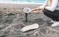 Young woman cleaning microplastics from sand on the beach - Environmental problem, pollution and ecolosystem warning concept - Royalty Free Stock Photo