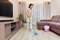 young woman cleaning and mopping floor at living room Royalty Free Stock Photo