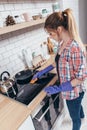 Young woman cleaning oven at home kitchen Hand wiping clean stove top and burner covers Royalty Free Stock Photo