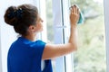 Young Woman cleaning window glass. Cleaning Company Worker Royalty Free Stock Photo