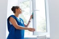 Young Woman cleaning window glass. Cleaning Company Worker Royalty Free Stock Photo