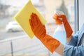 Young woman cleaning window glass at home