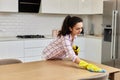 young woman cleaning wooden table with microfiber cloth. Royalty Free Stock Photo