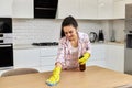 young woman cleaning wooden table with microfiber cloth. Royalty Free Stock Photo