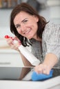 young woman cleans induction hob Royalty Free Stock Photo