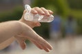 Young woman cleanses her hands with hydroalcoholic gel as a prevention method to avoid spreading COVID-19