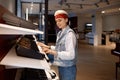 Young woman client choosing electric synthesizer at music shop store