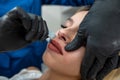 Young woman client get removing hair on the upper lip in face with hot sugar wax Royalty Free Stock Photo