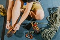 Young woman climber prepare before to climbing on the boulder wall indoor with equipment, shoe, rope, carabiner, concept Royalty Free Stock Photo