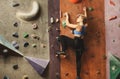 Young woman climbing artificial rock wall at gym Royalty Free Stock Photo