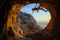 Young woman climbing in cave with beautiful sea view Royalty Free Stock Photo