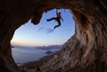 Young woman climbing in cave at sunset Royalty Free Stock Photo