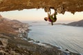 Young woman climbing in cave at sunset