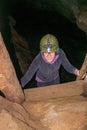 Young woman climbing ladder inside cave Royalty Free Stock Photo