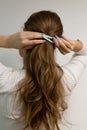 Young woman clipping her blond hair with a snap hair clip.