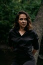 Young woman - close portrait in a dark forest. Woman in black shirt Royalty Free Stock Photo