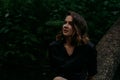 Young woman - close portrait in a dark forest. Woman in black shirt Royalty Free Stock Photo