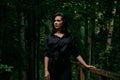 Young woman - close portrait in a dark forest. Woman in black shirt Royalty Free Stock Photo