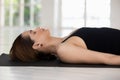 Young woman with closed eyes practicing yoga, Savasana, Corpse pose Royalty Free Stock Photo