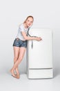 Young woman and closed fridge Royalty Free Stock Photo