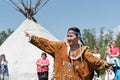 Young woman in clothing aborigine of Kamchatka dancing on background of yaranga