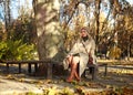 Young woman in a coat  in city spring park enjoys walk on sunny day Royalty Free Stock Photo