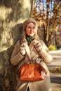 Young woman in a coat  in city spring park enjoys walk on sunny day Royalty Free Stock Photo