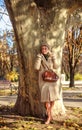 Young woman in a coat  in city spring park enjoys walk on sunny day Royalty Free Stock Photo