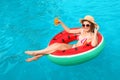 Young woman with cocktail in pool