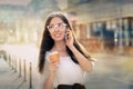 Young Woman with Coffee Cup on the Phone Out in the City Royalty Free Stock Photo