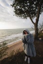 Young woman on cold autumn seashore posing at camera Royalty Free Stock Photo