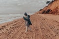 Young woman on cold autumn seashore posing at camera