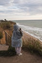 Young woman on cold autumn seashore posing at camera