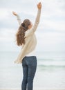 Young woman on cold beach rejoicing success Royalty Free Stock Photo