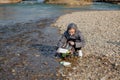 Young woman collecting plastic trash from the beach and putting it into black plastic bags for recycle. Cleaning and recycling