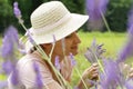 A young woman collects lavenderLavandula angustifolia , which smells beautiful and has a wonderful purple color. Summer time