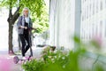 Young woman with colored dreadlocks  riding electric scooter Royalty Free Stock Photo