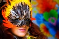 Young woman with a colorful feather carnival face mask on bright colorful background, eye contact, make up artist. Royalty Free Stock Photo